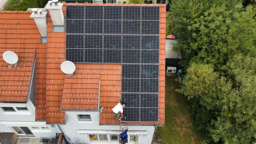 Luftaufnahme eines Hauses mit Photovoltaikanlage auf dem Ziegeldach
